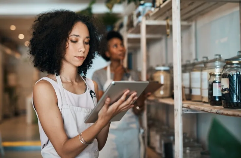 Two people taking stock with a tablet in a refill store